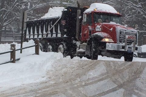 Truck hauling away a load of snow.